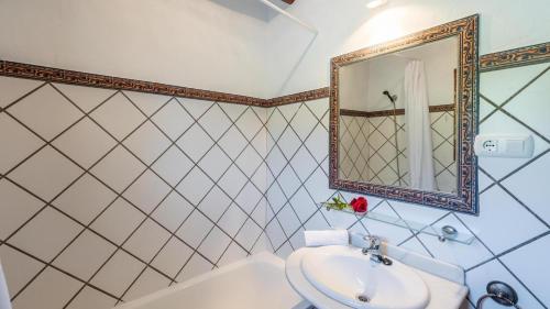 a bathroom with a sink and a mirror and a tub at Casa El Carril Benalauria by Ruralidays in Benalauría