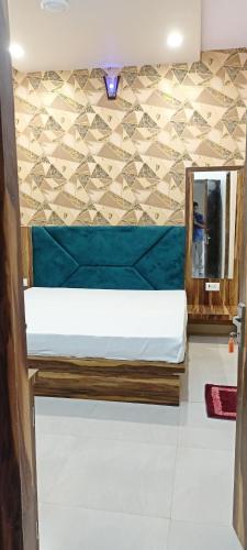a bed in a room with a wall at Hotel Keshavam inn in Mathura