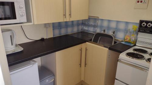 a small kitchen with a sink and a stove at The Kathrene Holiday Flats in Fleetwood