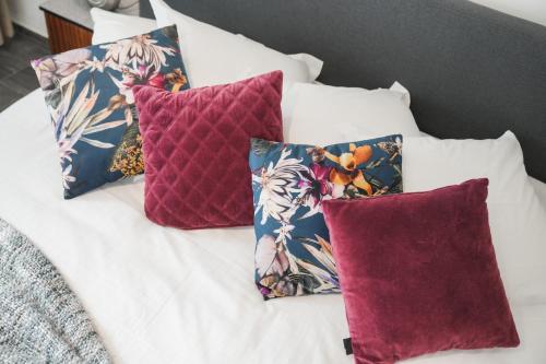 a group of four pillows on top of a bed at Villa Yvonne in Ostend