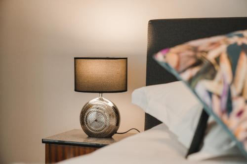 a lamp sitting on a table next to a bed at Villa Yvonne in Ostend