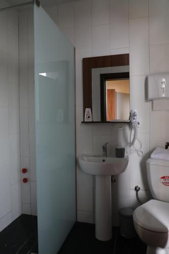 a bathroom with a sink and a toilet and a mirror at Hotel Hiserra in Prizren