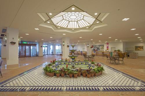 a lobby with a large room with plants and a window at Hotel Shima Spain Mura in Shima