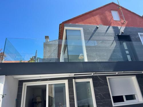 a house with glass windows on the side of it at PASEO MARÍTIMO PANXON in Nigrán