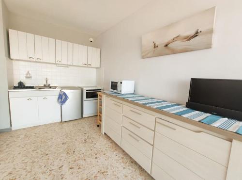 une cuisine avec des armoires blanches et un comptoir dans l'établissement Appartement vue Mer à la Grande Motte, à La Grande Motte