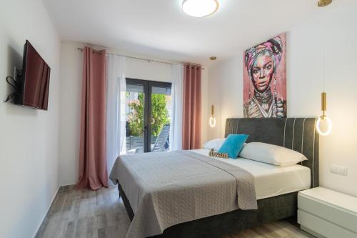 a bedroom with a bed and a painting on the wall at Apartmani PARDON in Pag