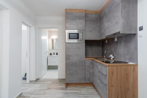 a kitchen with a sink and a microwave at Apartmani PARDON in Pag