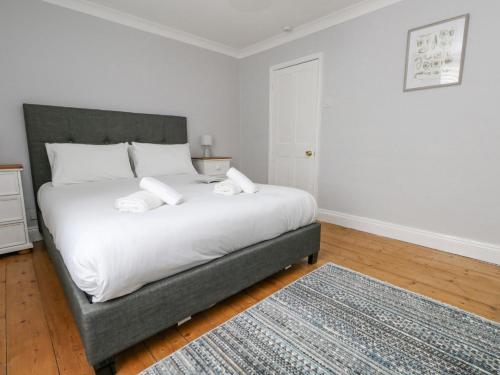 a bedroom with a bed with white sheets and a rug at Day Cottage in Weymouth