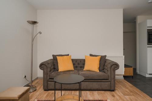 a living room with a couch with two orange pillows at Villa Yvonne in Ostend