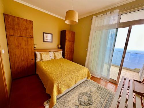 - une chambre avec un lit et une grande fenêtre dans l'établissement Villa Babel, à Garajau