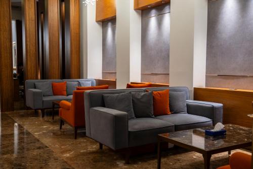 a waiting room with couches and orange pillows at Parwar Hotel in Duhok
