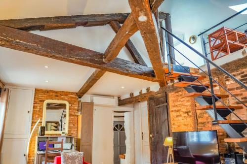 un escalier dans une pièce avec poutres apparentes dans l'établissement Appartement - Alcôve et chocolat - Albi, à Albi