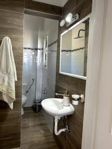 a bathroom with a sink and a toilet and a mirror at Our Home in Heraklio