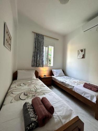 a bedroom with two beds and a window at Our Home in Heraklio