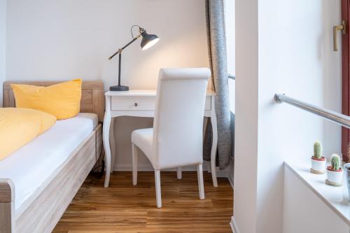 a bedroom with a desk and a bed with a chair at Gwuni Mopera in Leipzig