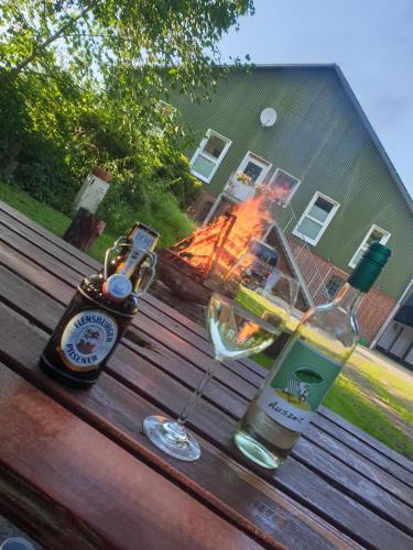 a table with two bottles and a glass of wine at Ferienwohnung Wiehelund - Kleinwiehe in Lindewitt