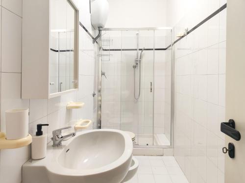 a white bathroom with a sink and a shower at Homiday - BordoPineta Centro in Pineto