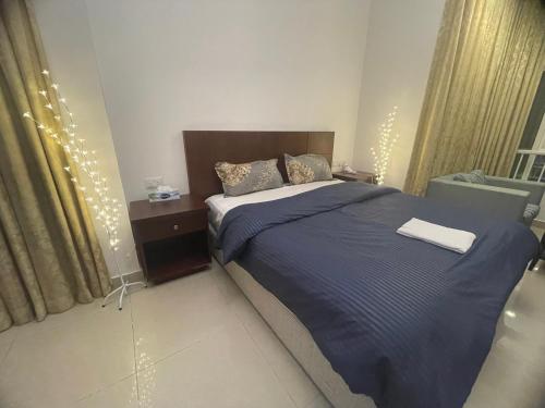 a bedroom with a bed with a blue comforter at Beautiful Furnished Studio Building Apartment 903 AL Nahyan in Abu Dhabi