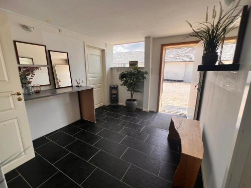 a room with a tile floor with a bench and mirrors at Country guesthouse in Gadstrup