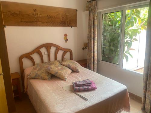 a bed in a room with a window and a table at RIERA BAIXOS in Tamariu