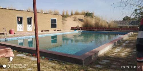 a large swimming pool in front of a building at Umaid Desert Camp, Raisar in Bikaner