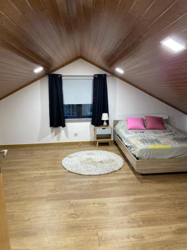 una camera da letto con un letto con cuscini rosa e una finestra di Moradia Activ Mar\Vão a Vila Real