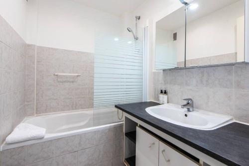 une salle de bain avec une baignoire et un lavabo et une baignoire dans l'établissement Cannes Branly :2BDR Apartment, à Cannes