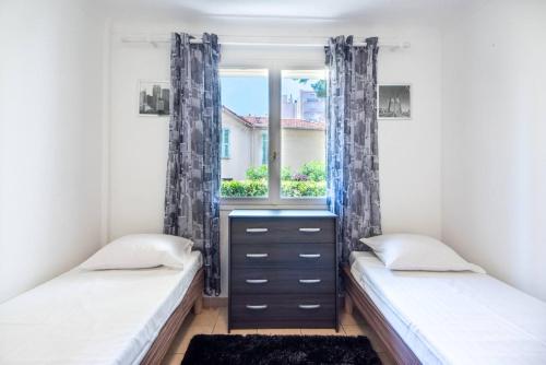deux lits dans une chambre avec une fenêtre dans l'établissement Cannes Branly :2BDR Apartment, à Cannes