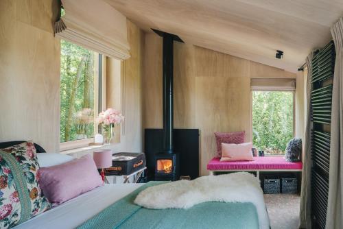 a bedroom with a bed and a wood stove at RewildThings Treehouses in Gloucester