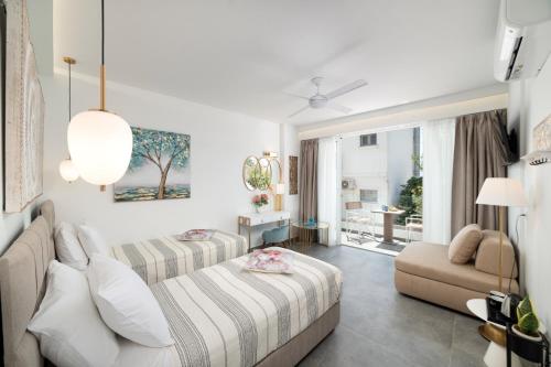 a hotel room with two beds and a couch at Serenita apartments 2 in Agios Nikolaos