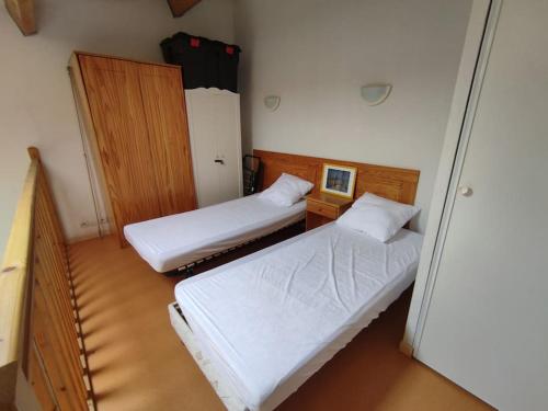 duas camas num pequeno quarto com em Charmante maisonnette de vacances em Calvisson