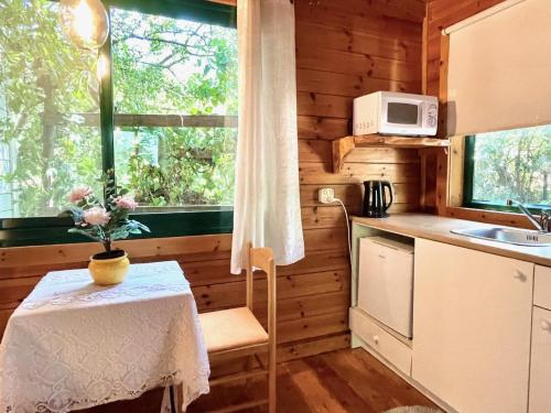 uma pequena cozinha com uma mesa e uma janela em Adventure - חוויה em Amirim