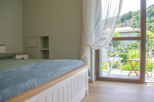 a bedroom with a bed and a sliding glass door at Casa Hemingway - WelcHome in Stresa