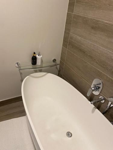 ein Badezimmer mit einer weißen Badewanne und einem weißen WC in der Unterkunft Luxurious Resorts in Pretoria
