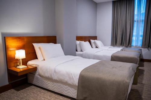a hotel room with two beds and a window at Parwar Hotel in Duhok