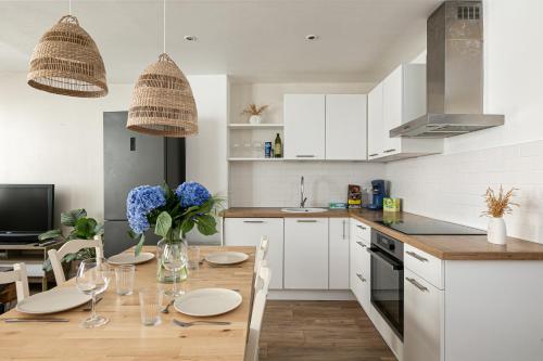 une cuisine avec une table en bois et des fleurs bleues. dans l'établissement Le Cocon - Proche Gare - Lumineux & Centre Ville - Commerces à Proximité, à Strasbourg