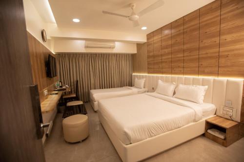 Habitación de hotel con cama blanca y baño. en Hotel Naaz Executive en Bombay