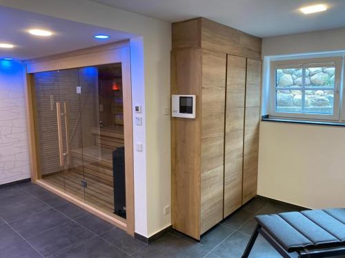 a room with a walk in shower and a glass door at Winkelschiffchen III mit Sauna in Juist