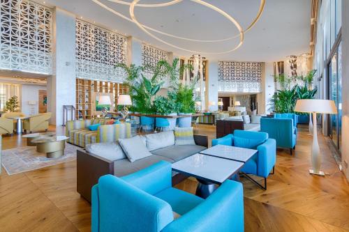 a lobby with blue chairs and tables at Akra Hotel in Antalya
