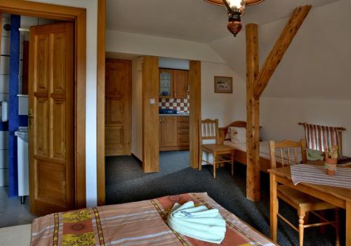 a room with a bed and a table and a kitchen at Penzion Lesní Zátiší in Horní Malá Úpa