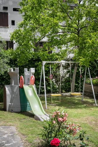 a playground with a slide in a park at Hotel San Marco in Gubbio