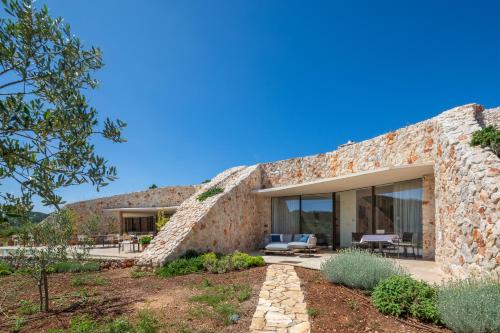 a stone house with glass doors and a patio at Villa Nai 3.3 in Žman