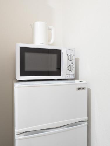 a microwave sitting on top of a refrigerator at japan house itabashi in Tokyo
