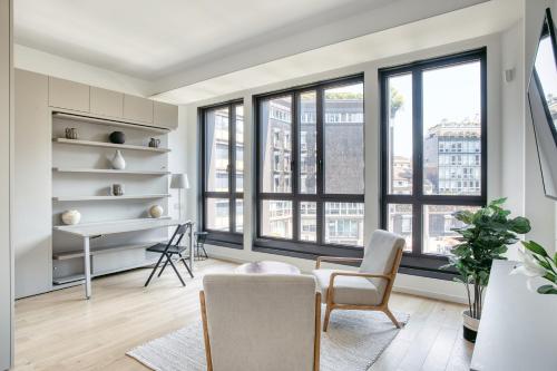 - un salon avec des fenêtres, un bureau et des chaises dans l'établissement JOIVY Chic studio close to Central Tower, à Milan
