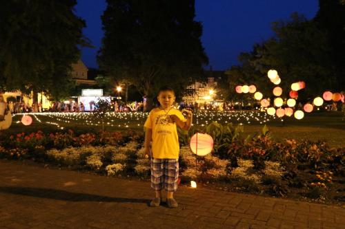 a young child holding an umbrella in a park at night at Hotel Alte Post in Bad Sooden-Allendorf