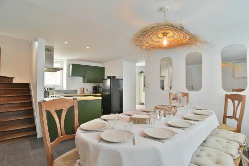 une salle à manger avec une table et une cuisine dans l'établissement La Paillotte - à 7min de la plage, à Beaussais sur Mer