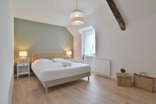 ein Schlafzimmer mit einem weißen Bett und einem Fenster in der Unterkunft La Paillotte - à 7min de la plage in Beaussais sur Mer