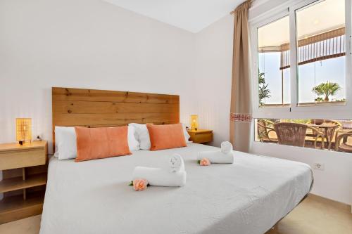 ein Schlafzimmer mit einem großen Bett mit zwei ausgestopften Tieren darauf in der Unterkunft Vistamarina A309 By IVI Real Estate in Torremolinos