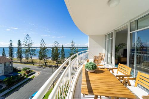 a balcony with a wooden table and a view of the ocean at Ocean View 2BR Apartment and SPA in Gold Coast