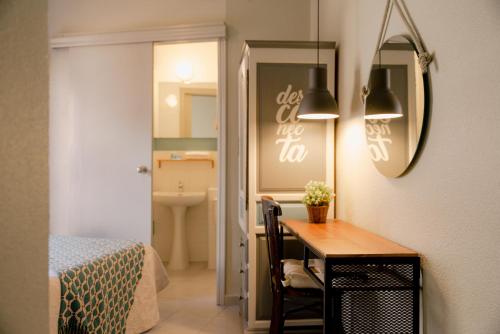 アルカンタリージャにあるVicente Homeのテーブル、ベッド、鏡が備わる客室です。